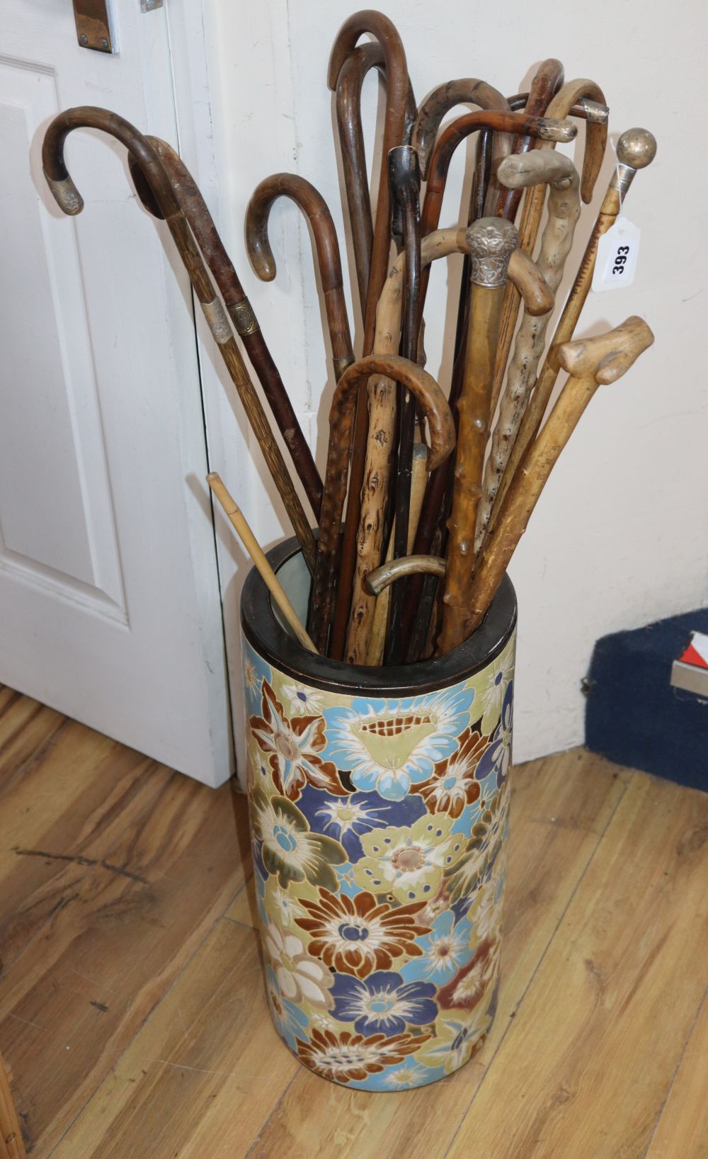 A group of assorted walking canes, some silver mounted, in a ceramic stand